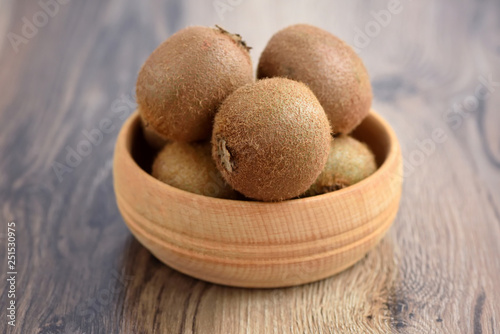 Kiwi fruit in a bowl on wooden background