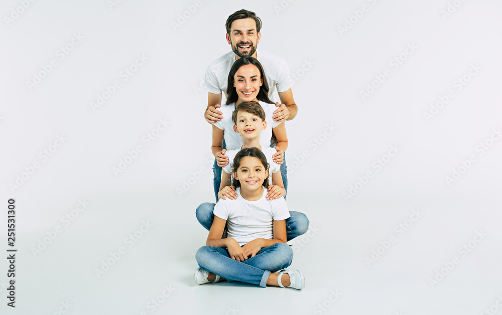 Happy cute smiling family looking on camera isolated on white studio