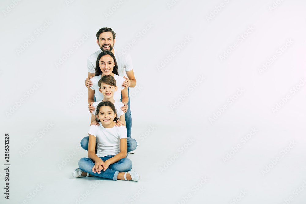 Happy cute smiling family looking on camera isolated on white studio - obrazy, fototapety, plakaty 