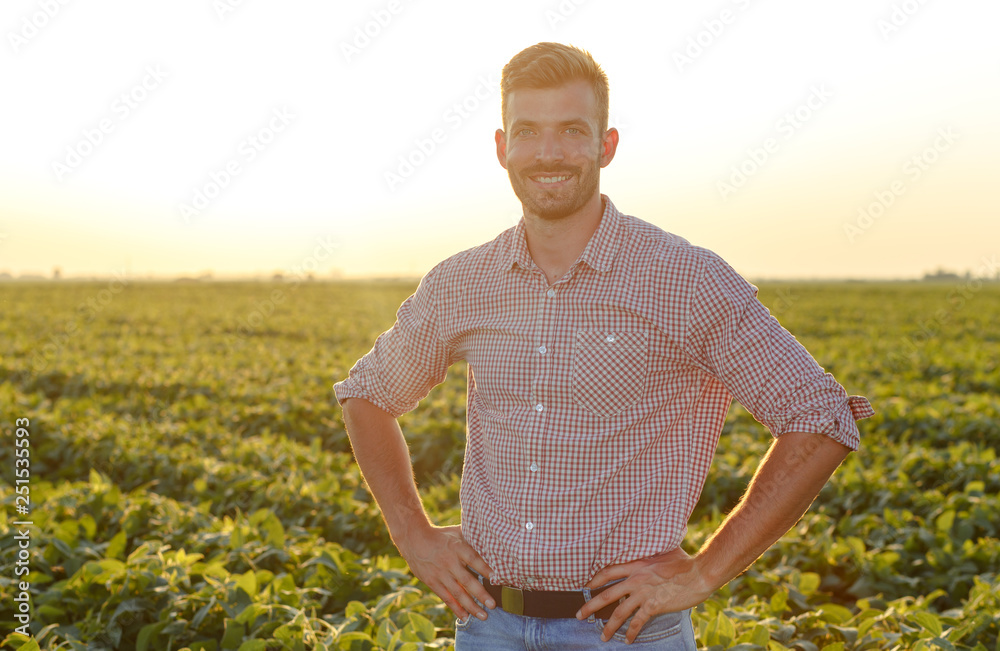 Portrait of young farmer standing in soybean field at sunset. Portrait of young farmer standing in soybean field at sunset.