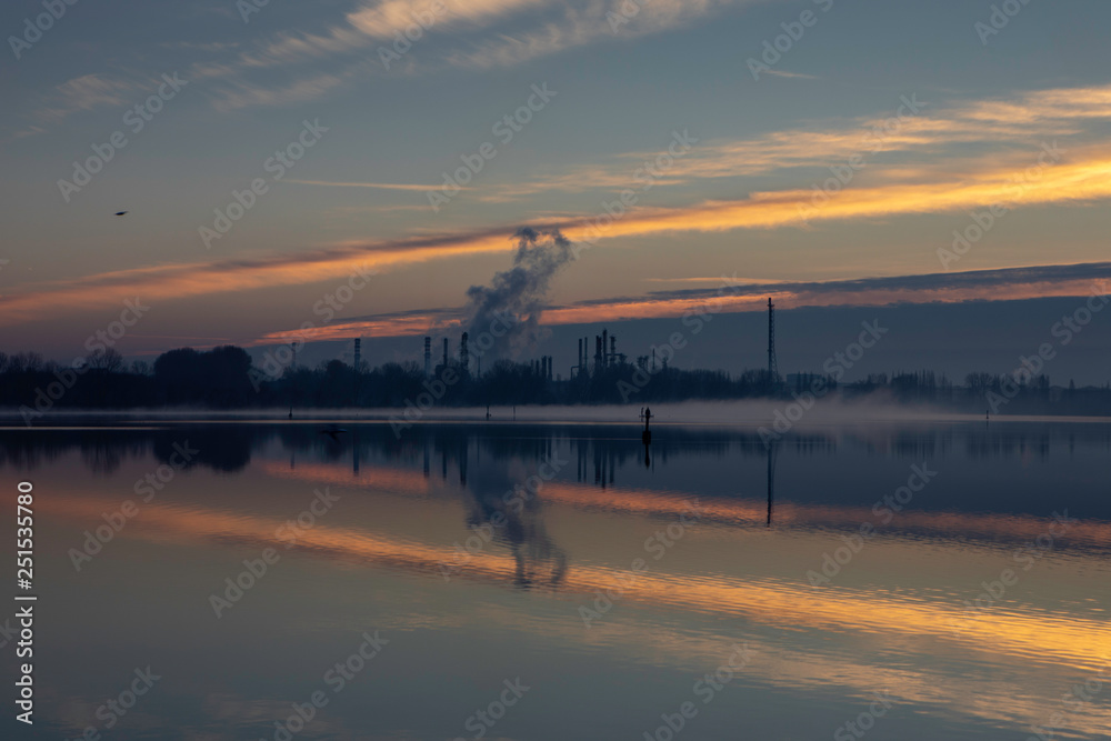 Dawn on a lake with industrial background