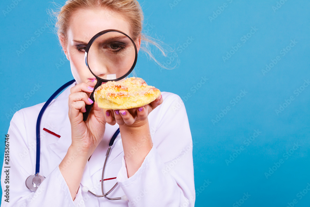 Doctor with magnifying glass examining sweet food Doctor with magnifying glass examining sweet food