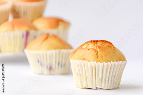 Fresh tasty muffins with berries on white background. Close up. Side view