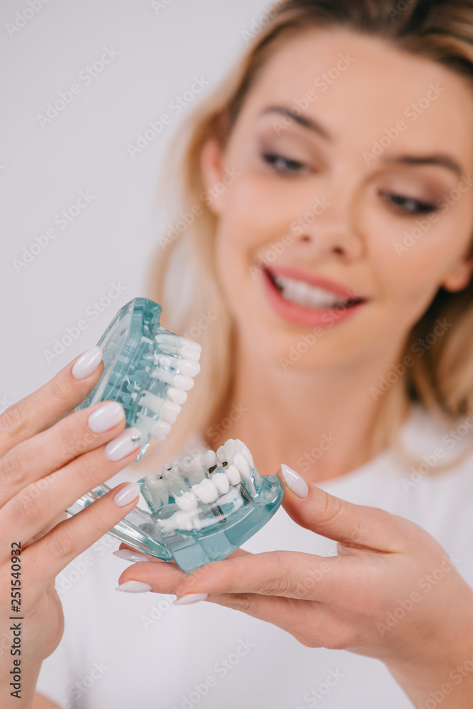 smiling woman holding jaw model isolated on white smiling woman holding jaw model isolated on white