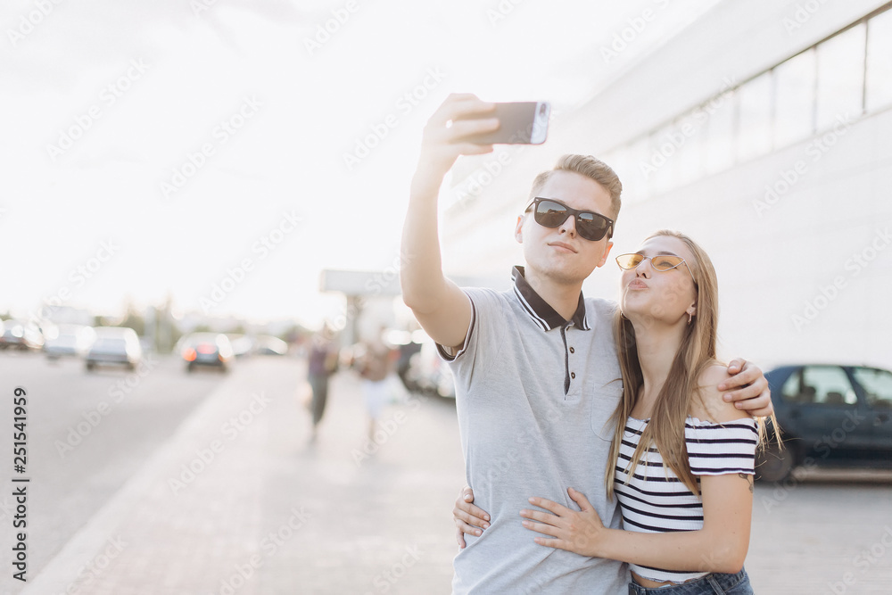 Capturing bright moments. Joyful young loving couple making selfie on camera while standing outdoors