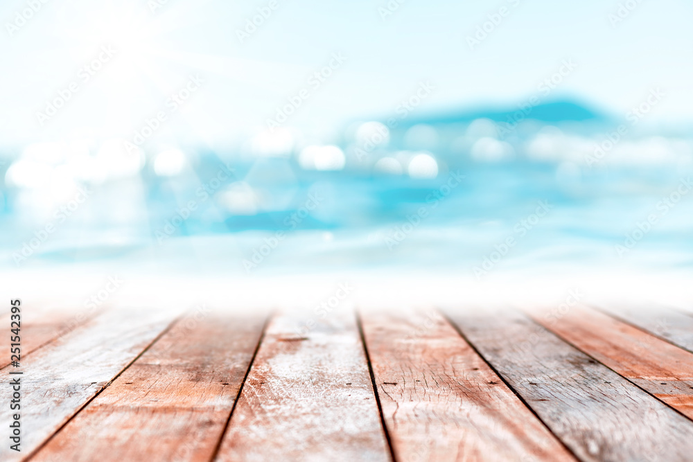 Blur tropical beach with bokeh sun light wave on empty old wood table abstract background. Blur tropical beach with bokeh sun light wave on empty old wood table abstract background.