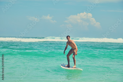 Surfer man with surfboard enjoying on the beach. Summer concept.