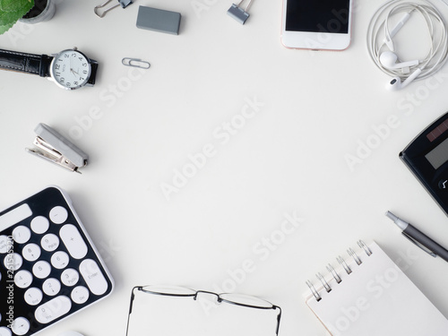 top view of office desk table with notebook, calculator, plastic plant, smartphone and keyboard on white background, graphic designer, Creative Designer concept.