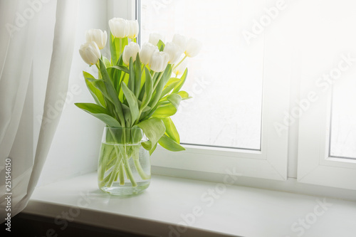 Bouquet of white tulip on windowsill. Copy space.