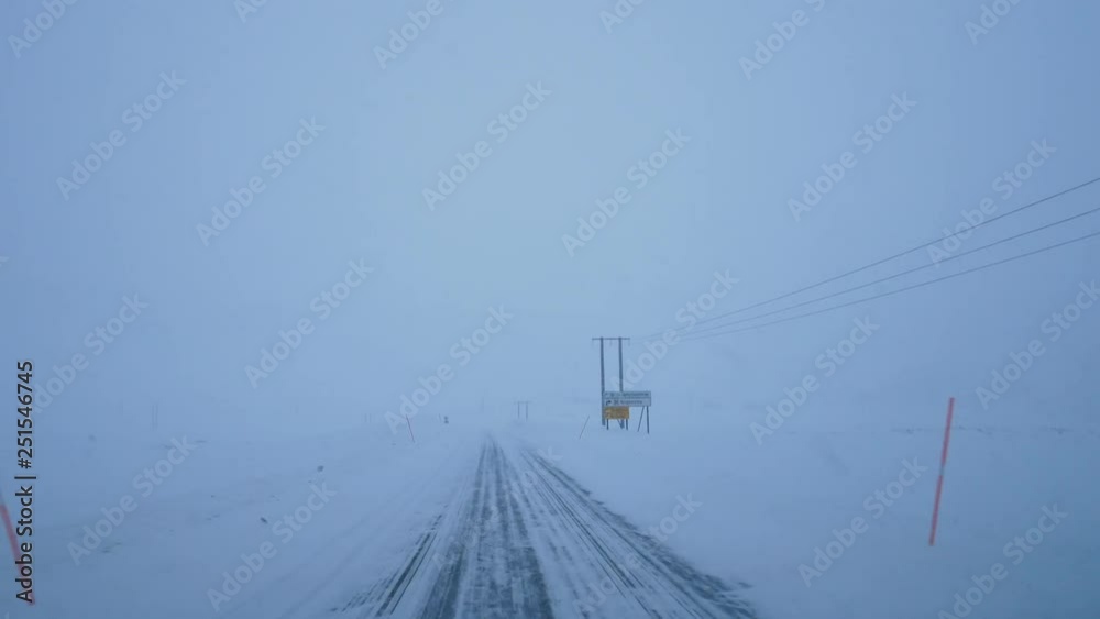 Driving down snowy road in winter blizzard, Lofoten Islands, Norway Driving down snowy road in winter blizzard, Lofoten Islands, Norway