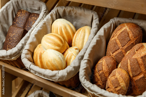 Assortment of fresh bread in baskets in bakery