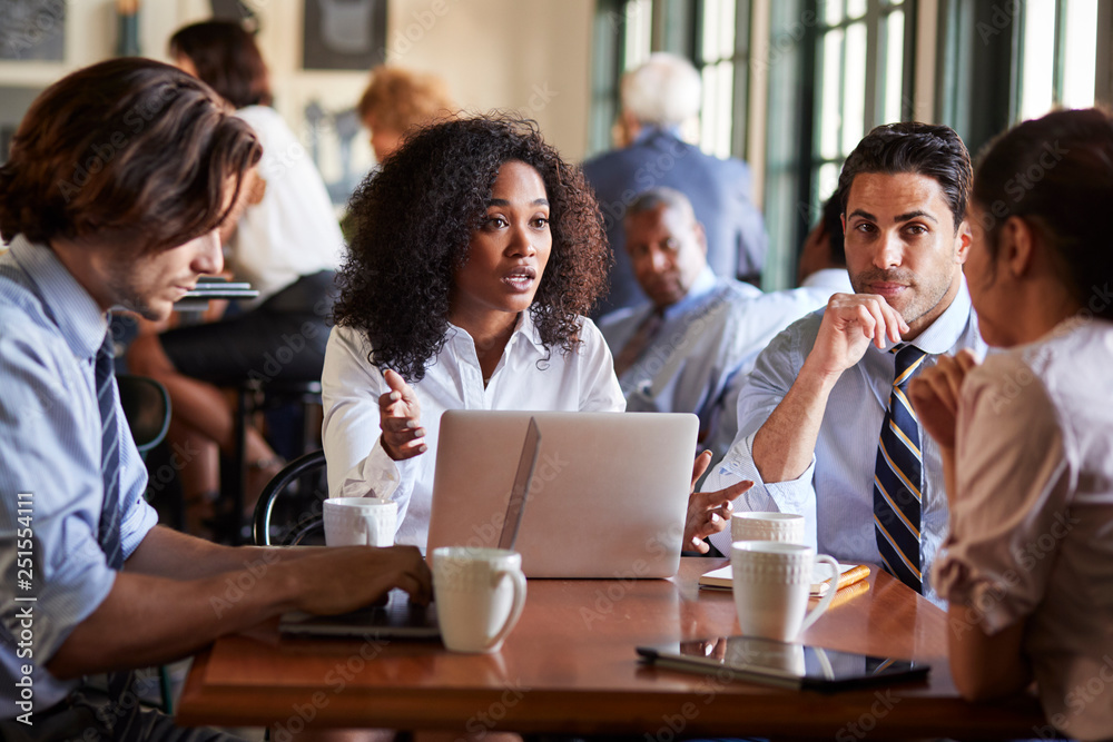 Business Team Having Informal Meeting Around Table In Coffee Shop Business Team Having Informal Meeting Around Table In Coffee Shop