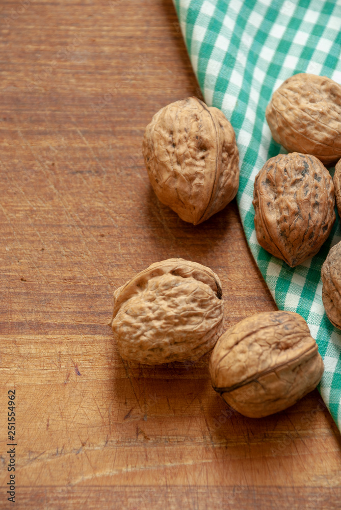 Walnuts on wooden background and green and white checkered cloth Walnuts on wooden background and green and white checkered cloth