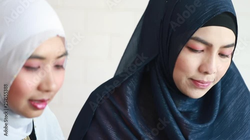 Young Muslim business woman holding tablet and type with computer at office.