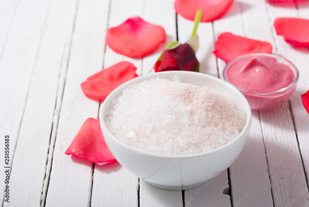perfume, body care and beauty products with red roses, pink petals on white wood table