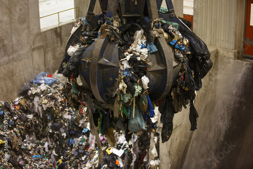 Obraz na płótnie Mechanical claw hand grabbing pile of mixed waste w salonie