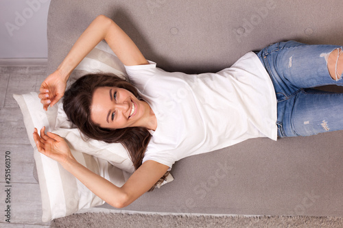 beautiful happy young woman lying on a sofa