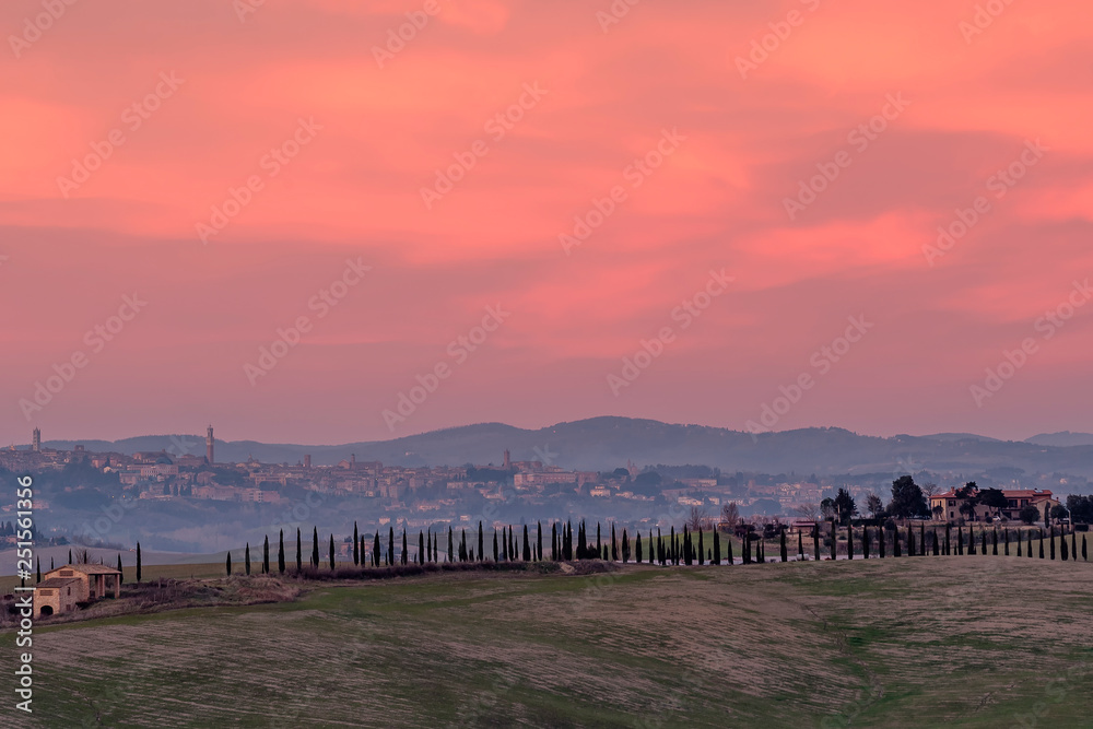 Beautiful sunset on the countryside with Siena in the background, Tuscany, Italy