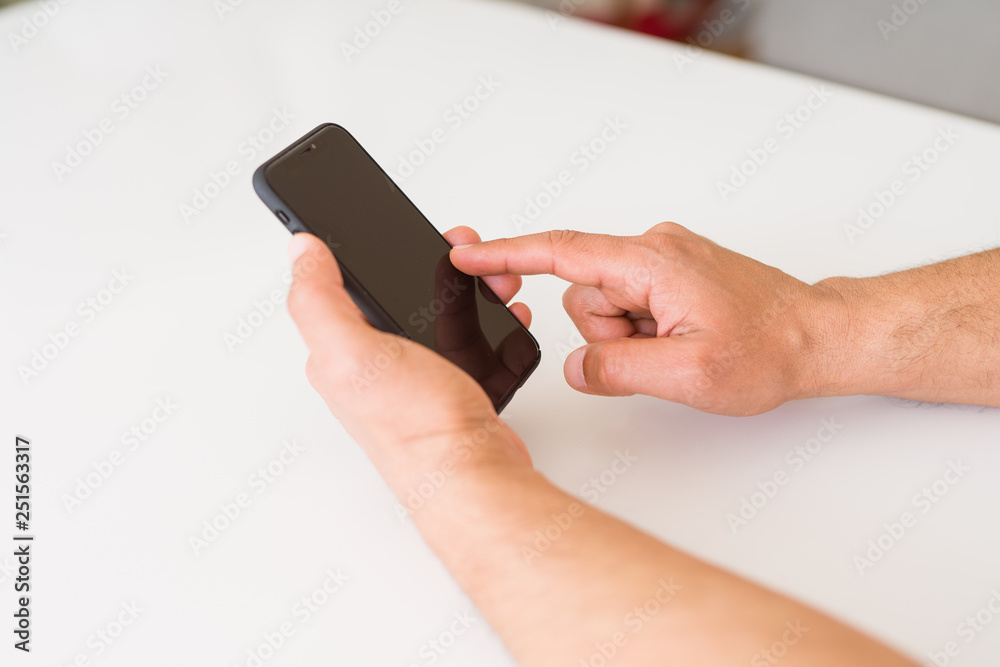 Close up of middle age man hands using smartphone at home Close up of middle age man hands using smartphone at home