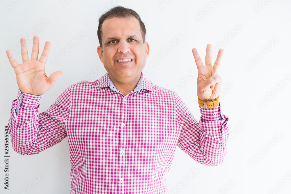 Naklejka premium Middle age man wearing business shirt over white wall showing and pointing up with fingers number eight while smiling confident and happy.