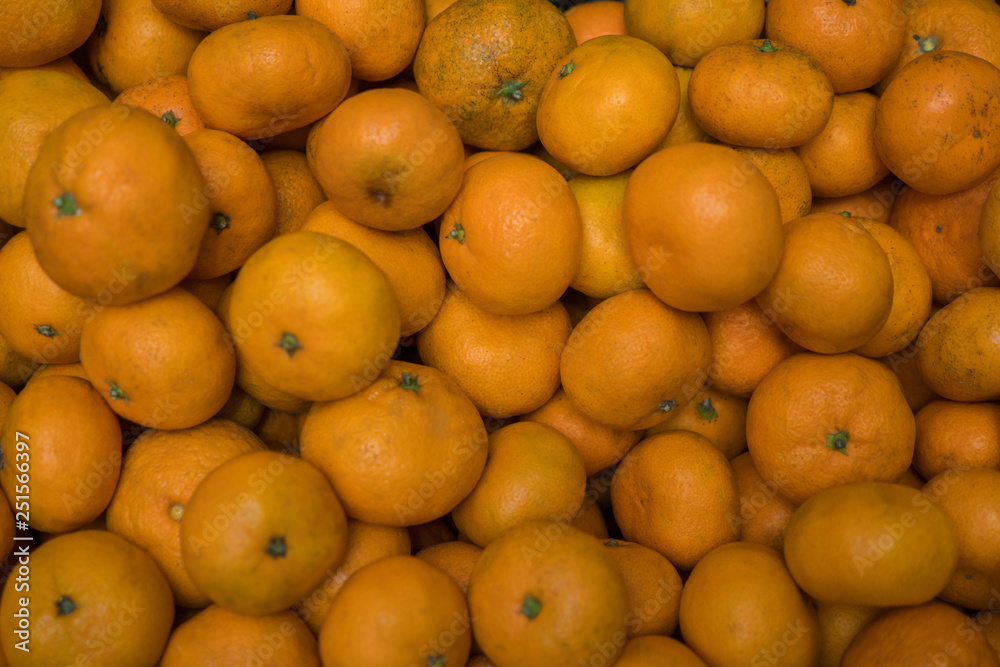 Many small ripe juicy mandarins in the box. Background Many small ripe juicy mandarins in the box. Background