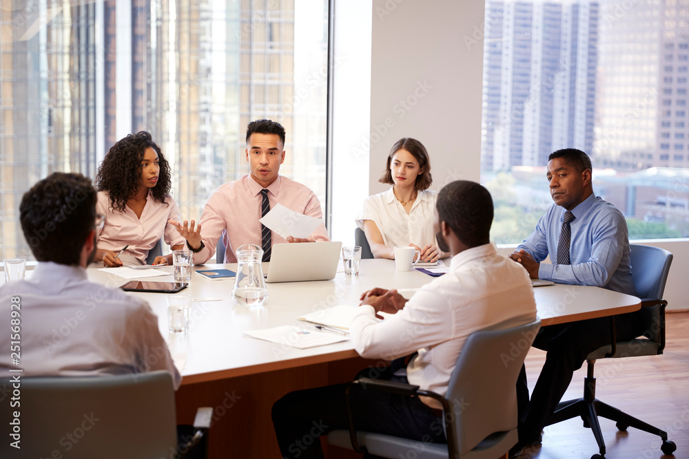 Group Of Business Professionals Meeting Around Table In Modern Office Group Of Business Professionals Meeting Around Table In Modern Office
