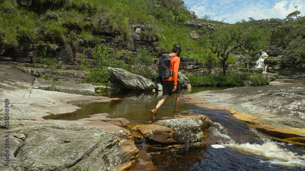 Obraz premium Man exploring nature with backpack and camera