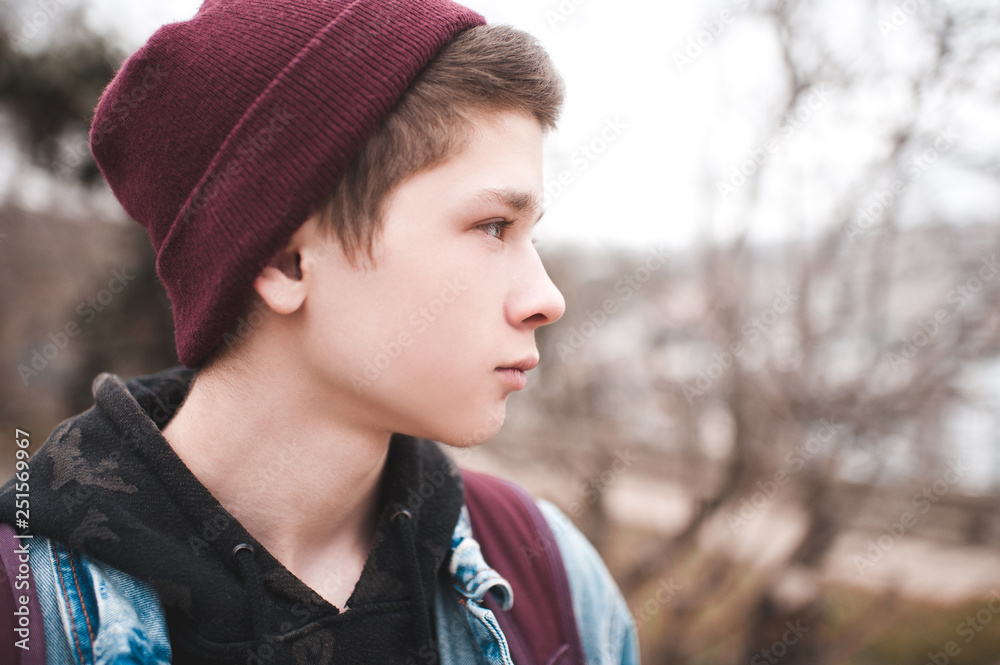 Portrait of teen boy 17-18 year old wearing knitted hat outdoors close up.  Stock-foto | Adobe Stock