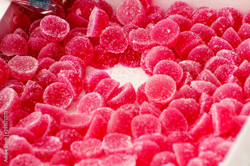 Many gelatin sweet red strawberries fruit candy candies sugar. Assorted color jelly sweets. Pile of colored confectionery for kids. Delicious gummy candies fruit flavor of blackberry and raspberry.
