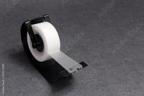 Angled view of sticky tape dispenser on gray background