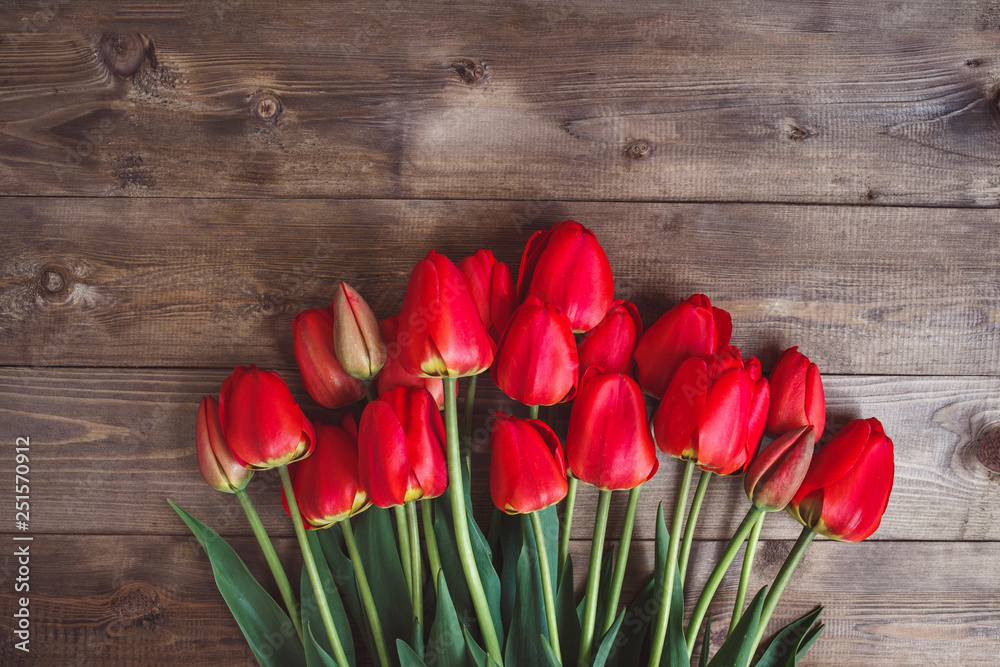 Fototapeta Row of red tulips on wooden background with space for message. Mother's Day background. Top view. Flat lay