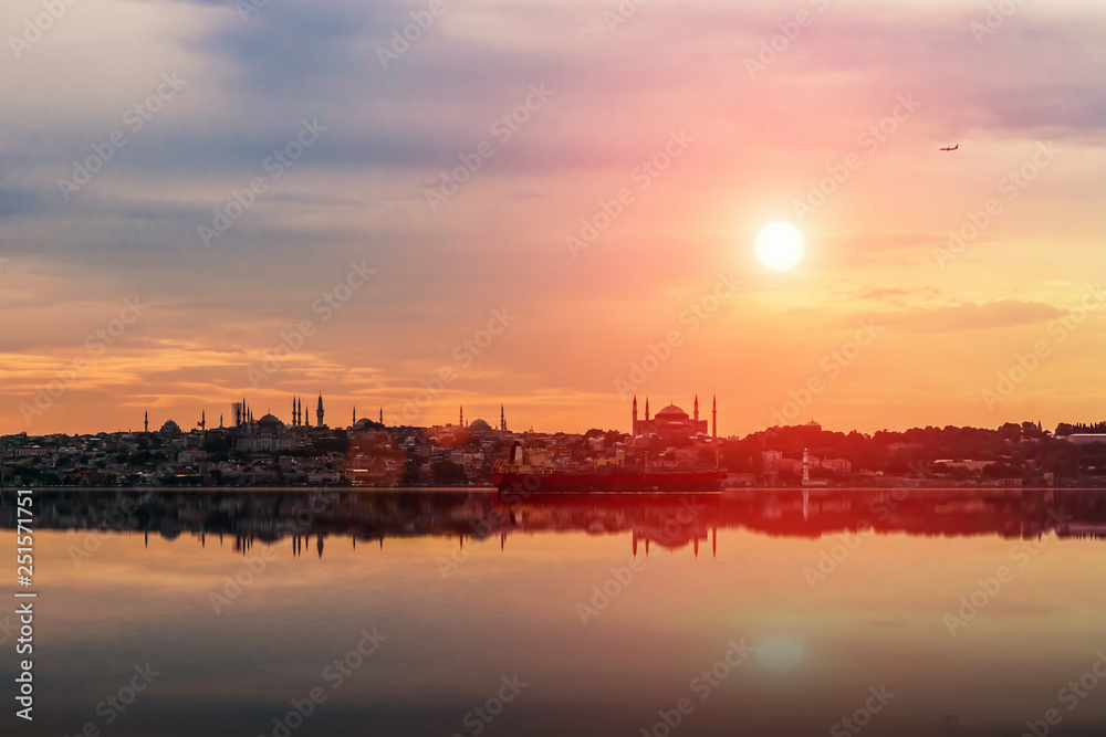 View of a general cargo ship passing the coastline of Istanbul at sunset.