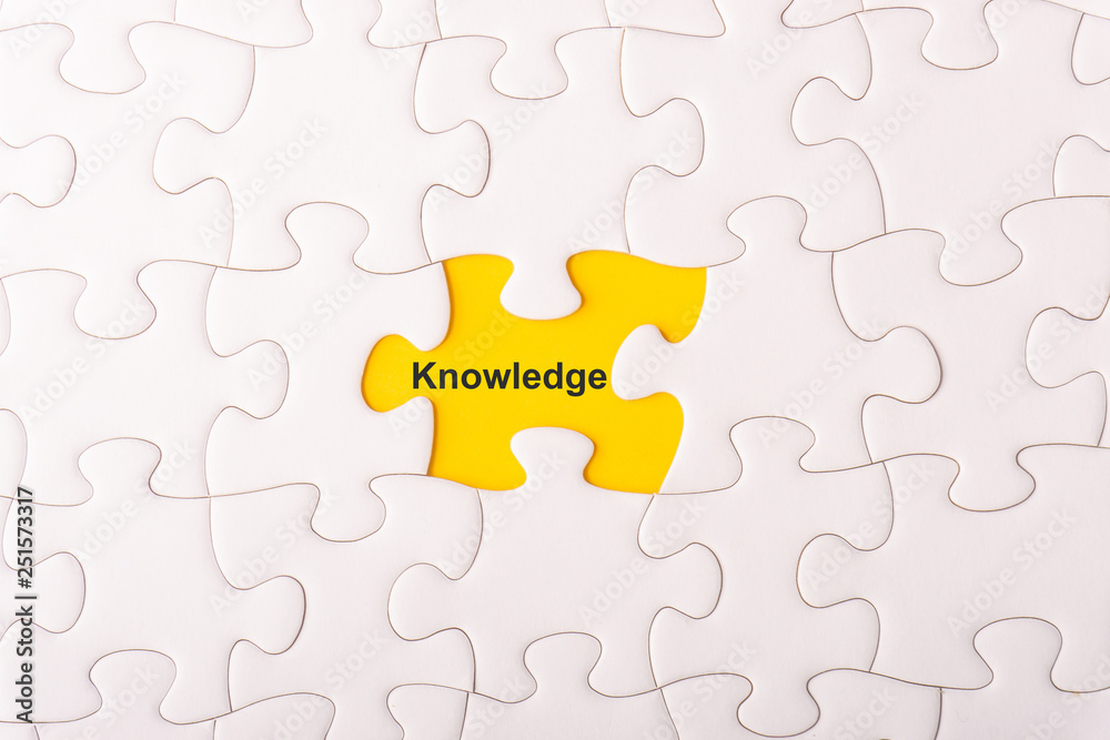 White jigsaw puzzle and missing pieces with words KNOWLEDGE selective focus and crop fragment White jigsaw puzzle and missing pieces with words KNOWLEDGE selective focus and crop fragment