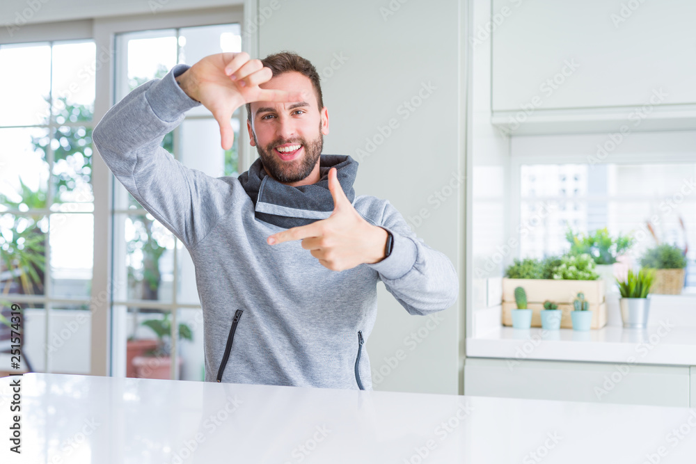 Handsome man at home smiling making frame with hands and fingers with happy face. Creativity and photography concept. Handsome man at home smiling making frame with hands and fingers with happy face. Creativity and photography concept.