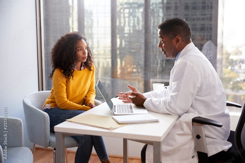 Serious Woman Having Consultation With Male Doctor In Hospital Office Serious Woman Having Consultation With Male Doctor In Hospital Office