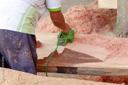 people's activities are smoothing wood with a machine