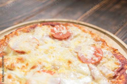 Ready-made pizza on wooden background.
