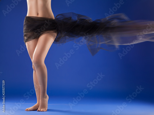 beautiful female body with black fabric loop on a blue background