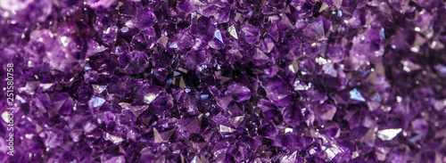 Amethyst purple crystal. Mineral crystals in the natural environment. Texture of precious and semiprecious gemstone.