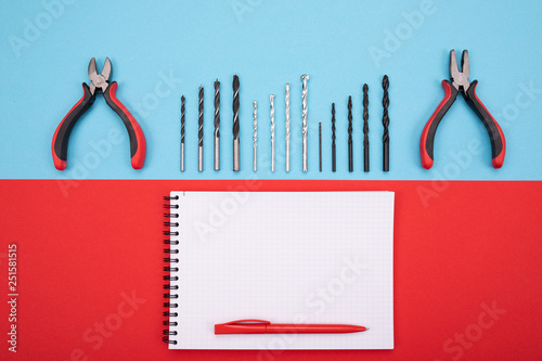 set of metalwork tools with notebook and pen on colorful background photo