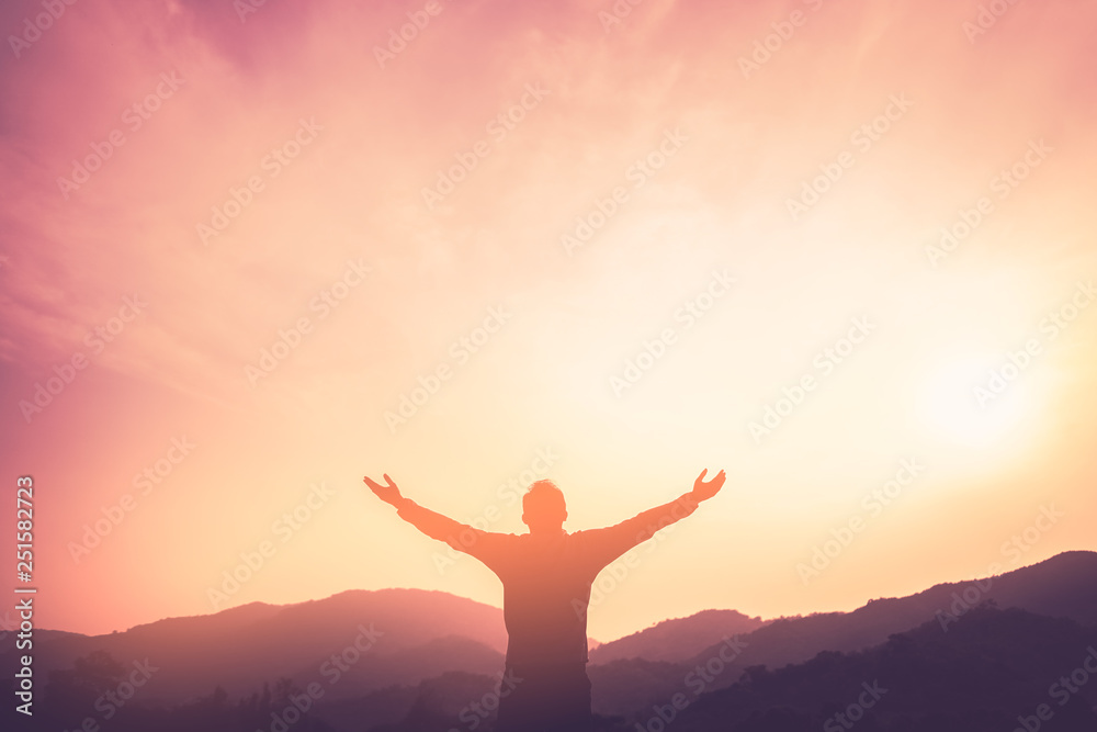 Copy space of man rise hand up on top of mountain and sunset sky abstract background.