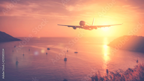 Airplane flying over tropical beach with smooth wave and sunset sky abstract background. © tonktiti