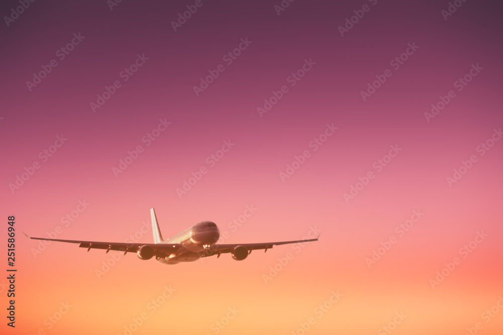Fototapeta premium Airplane flying on sunset sky abstract background. Copy space of business summer vacation and travel adventure concept.