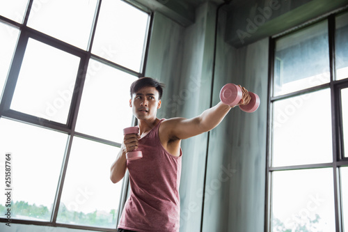 man punching and holding dumbell for exercising boxing indoor