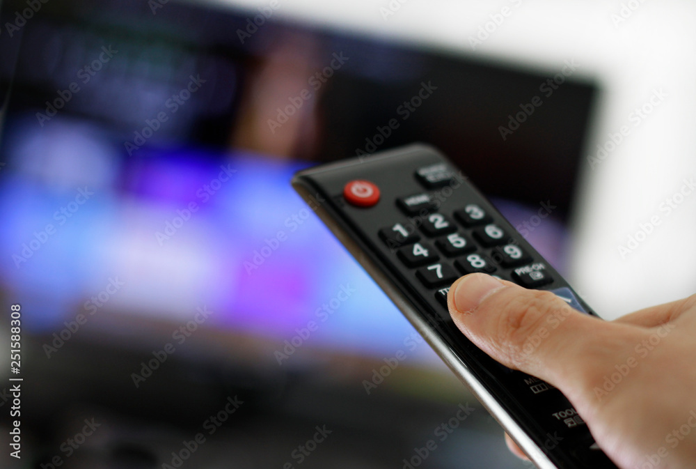 Hand holding remote control: Binge watching TV show Hand holding remote control: Binge watching TV show