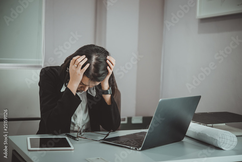 Asian woman working in office,young business woman stressed from work overload with a lot file on the desk,Thailand people thinking something
