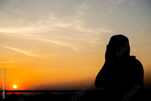 Silhouette Young asian muslim man praying on sunset,Ramadan festival concept