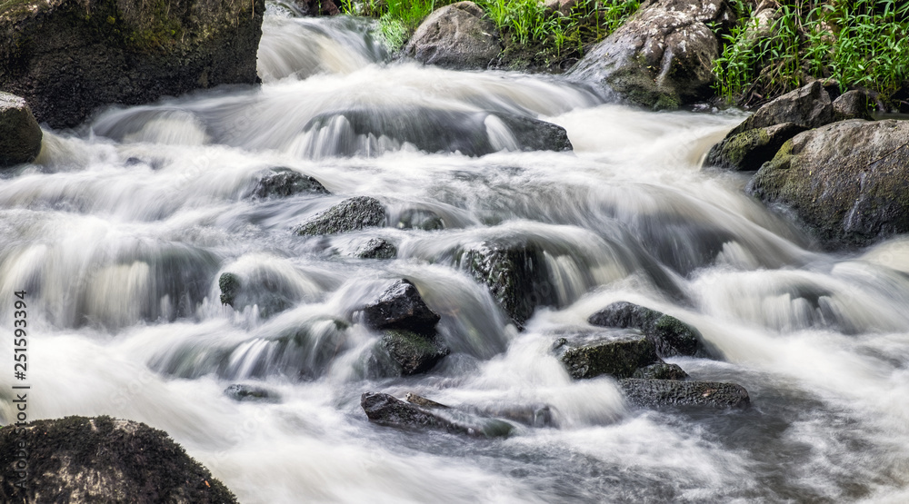 Beautiful rapid with fast flowing water and rocks, long exposure. Natural seasonal travel outdoor background in Finland