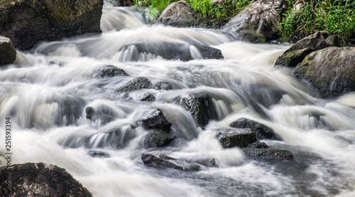 Fototapeta Naklejka Na Ścianę i Meble -  Beautiful rapid with fast flowing water and rocks, long exposure. Natural seasonal travel outdoor background in Finland