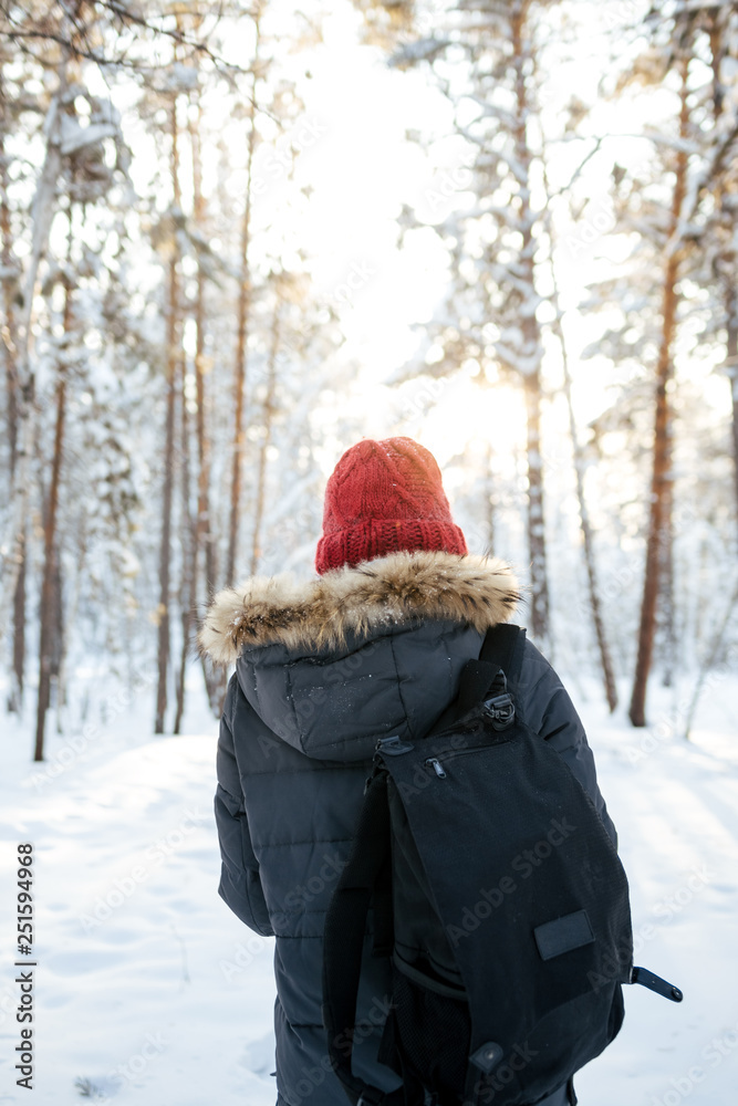 Girl in a red hat in the winter forest